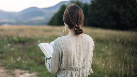 Girl walking and reading bible 