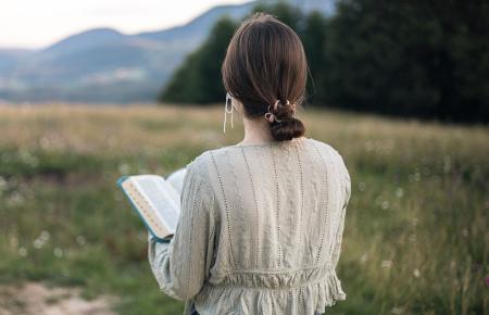 Girl walking and reading bible 