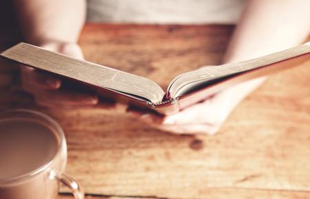 Female hands open Bible