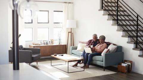 Couple sitting on sofa viewing a laptop