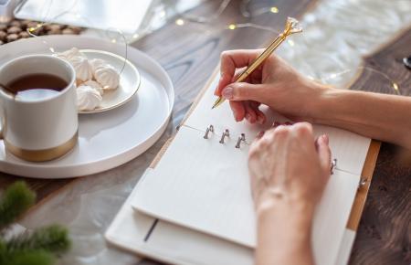 Woman writing and drinking coffee