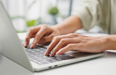 hands typing on laptop